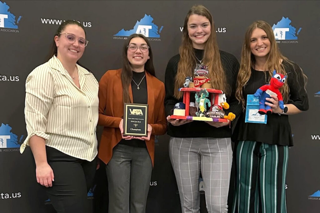 Students and a faculty member pose with the VATA Student Quiz Bowl trophy and plaque.