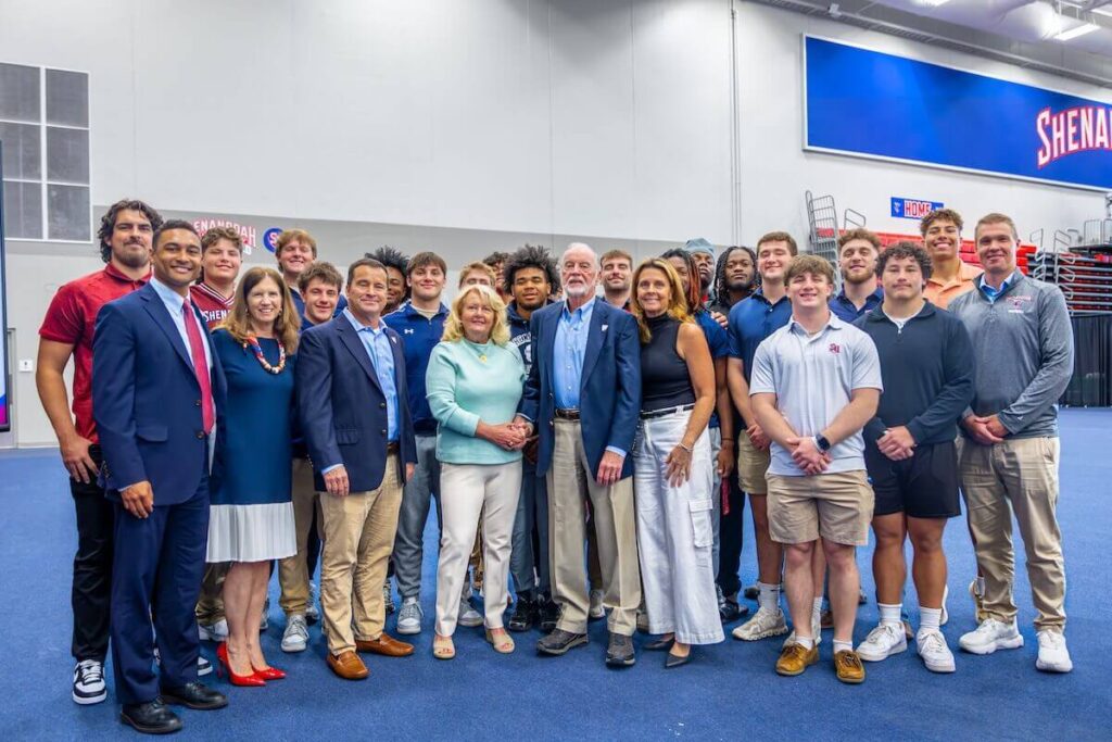 Shenandoah University football players pose with university administration and members of the Wilkins family.